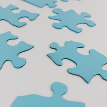 pexels photo 8385738 Close-up of blue puzzle pieces on a white surface, concept of problem-solving and integration.